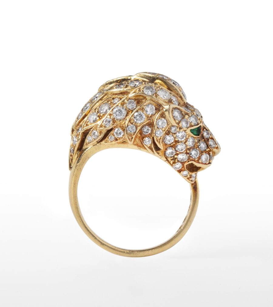 Een achttien karaat geelgouden ring in de vorm van een leeuwenkop bezet met diamanten, de ogen smaragden. Vervaardigd door Georges Lenfant, Parijs, ca 1970.