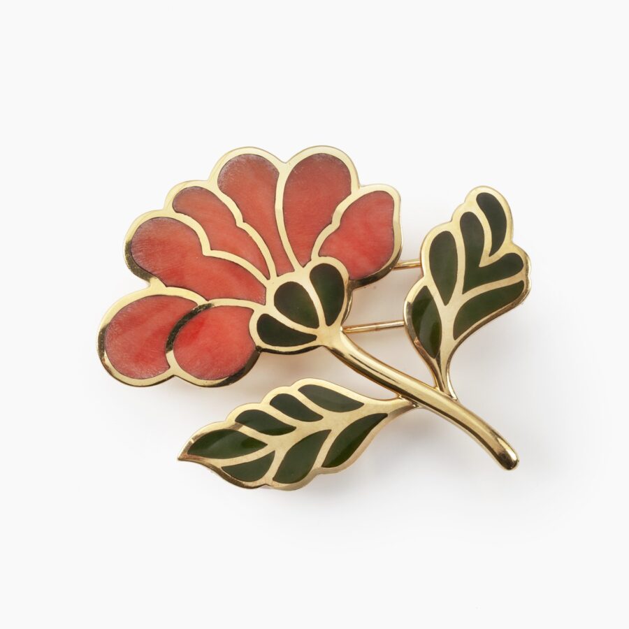 Een achttien karaat geelgouden broche in de vorm van een bloem, de bloem zelf ingelegd met koraal, de blaadjes met nefriet. Gesigneerd Tiffany & Co.