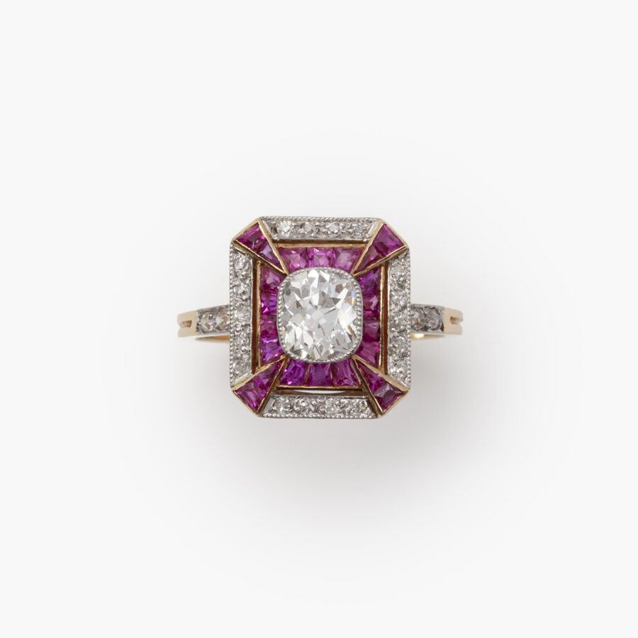 Een achttien karaat rosé goud en platina Art Deco ring bezet met diamanten en robijnen, vervaardigd in Frankrijk, omstreeks 1910.