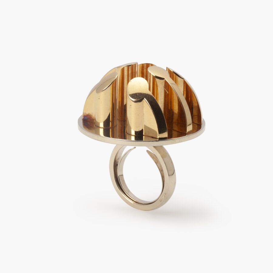 Een achttien karaat geel- en witgouden ring bestaande uit een witgouden schijf waarop zes pilaren. Gesigneerd Arnaldo Pomodoro, genummerd en gedateerd 1970. 