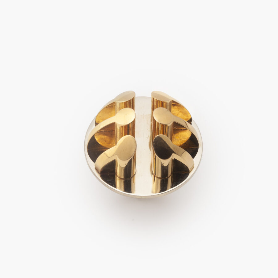 Een achttien karaat geel- en witgouden ring bestaande uit een witgouden schijf waarop zes pilaren. Gesigneerd Arnaldo Pomodoro, genummerd en gedateerd 1970. 