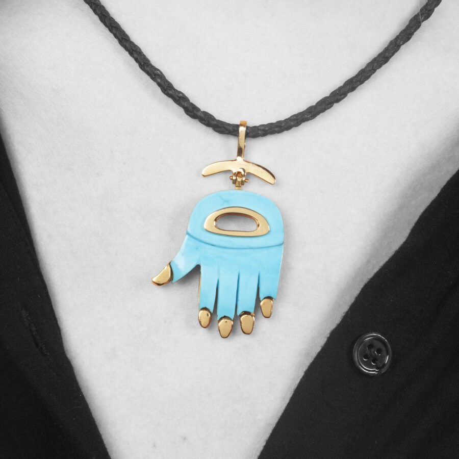 Een achttien karaat geelgouden hanger “Hamsa” ingelegd met turkoois. Gesigneerd Aldo Cipullo, vervaardigd in New York, omstreeks 1970.