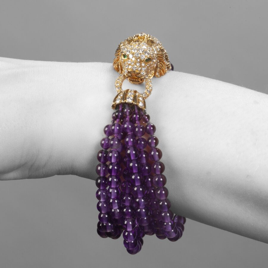 Een geelgouden armband ‘Lion Barquerolles’ bestaande uit een slot in de vorm van een leeuwenkop en kralen amethist, door Van Cleef & Arpels, New York, 1971.